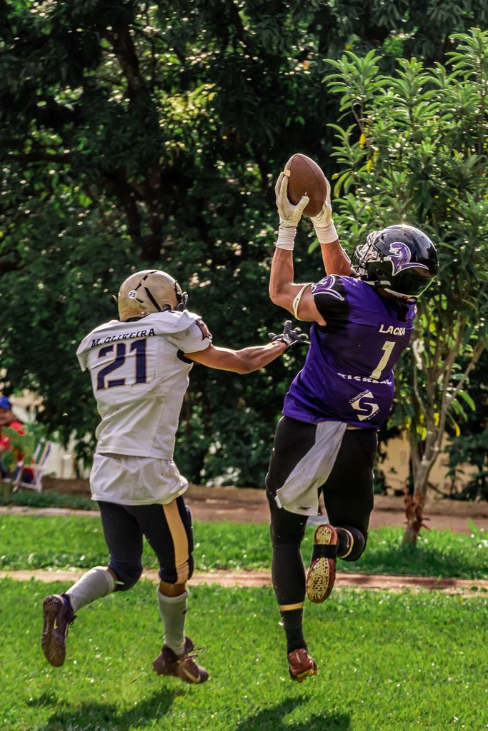 Two players in a thrilling moment of an American football game, outdoors.