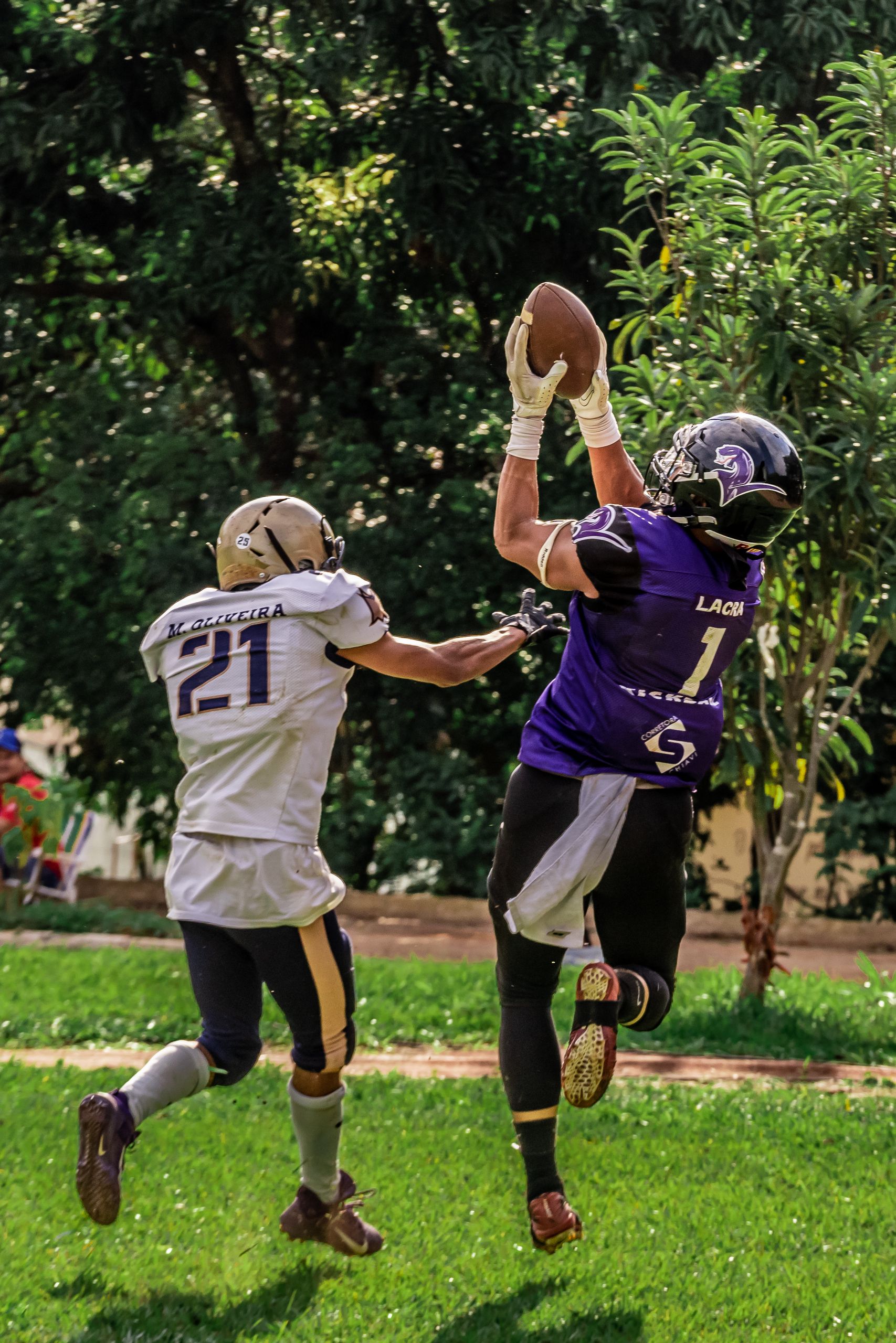 Two players in a thrilling moment of an American football game, outdoors.